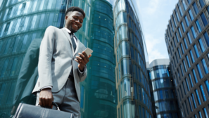 black man happy in front of glass buildings